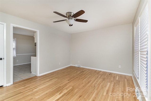 empty room with visible vents, baseboards, ceiling fan, and light wood finished floors