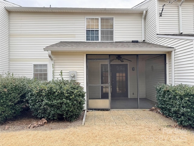 doorway to property with a shingled roof