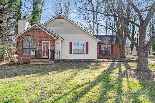 ranch-style home featuring brick siding, a chimney, and a front lawn