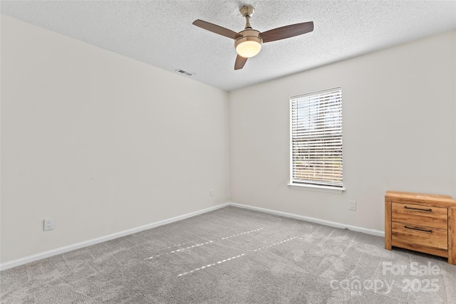 carpeted empty room featuring visible vents, a textured ceiling, baseboards, and a ceiling fan