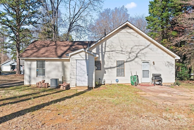 rear view of house with an outdoor structure, a yard, and central AC