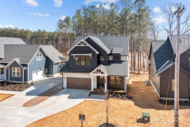 view of front of home featuring a garage, a shingled roof, concrete driveway, central air condition unit, and board and batten siding