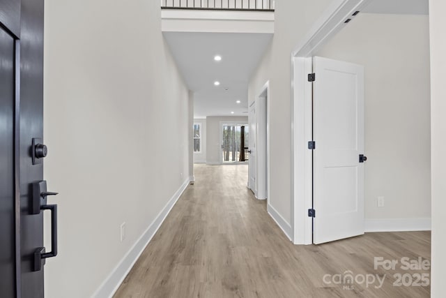 hallway with recessed lighting, wood finished floors, and baseboards