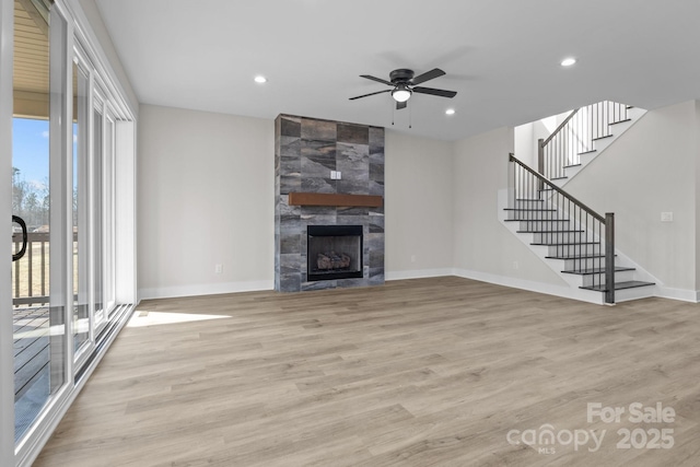 unfurnished living room featuring light wood-type flooring, a fireplace, baseboards, and recessed lighting