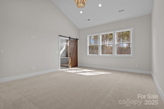 spare room with a barn door, visible vents, carpet flooring, high vaulted ceiling, and recessed lighting