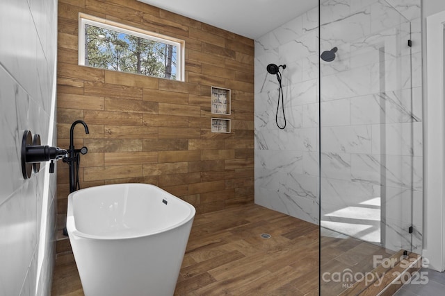 bathroom with a freestanding tub and a marble finish shower