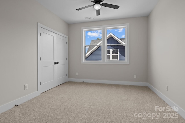 unfurnished bedroom featuring a ceiling fan, carpet, visible vents, and baseboards