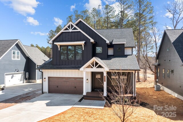 modern farmhouse style home with board and batten siding, a shingled roof, concrete driveway, an attached garage, and central AC