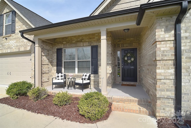 view of exterior entry featuring brick siding and covered porch