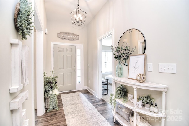 foyer with baseboards, dark wood-style flooring, and a chandelier