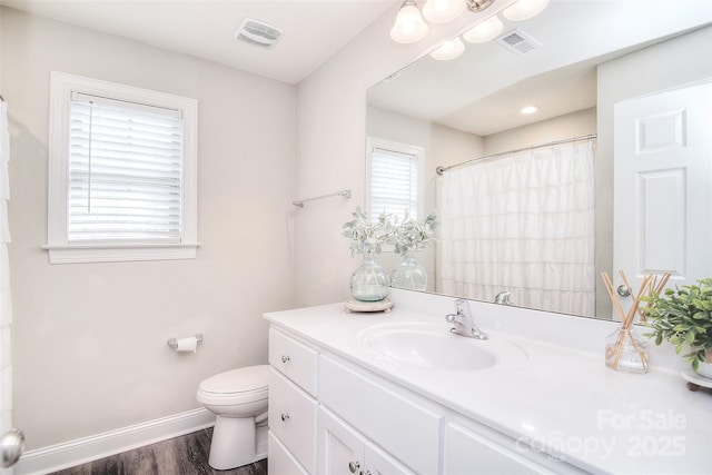 full bathroom with vanity, toilet, baseboards, and visible vents