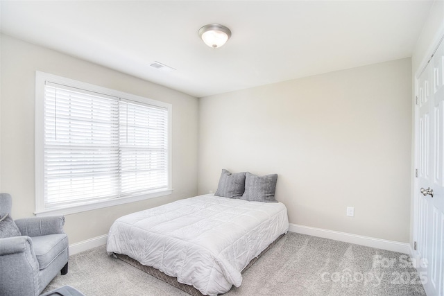 bedroom with visible vents, carpet floors, baseboards, and a closet