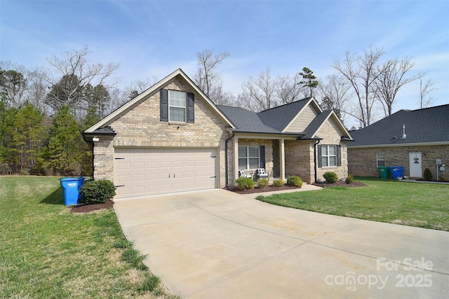 traditional home with a front yard, a garage, brick siding, and driveway