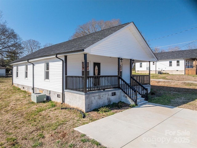 view of front facade with roof with shingles, a porch, crawl space, and central AC unit