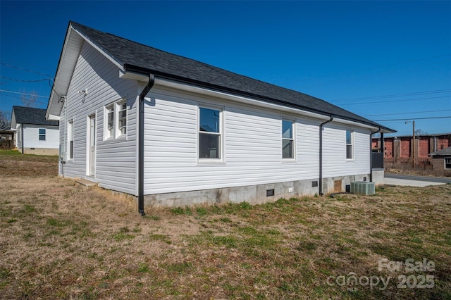 view of side of home featuring central AC, crawl space, and a lawn