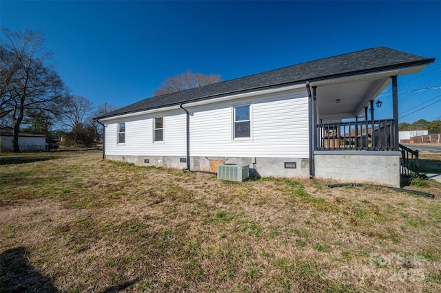 back of house featuring central AC, a shingled roof, crawl space, and a lawn