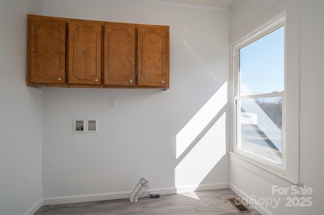 laundry area featuring hookup for a washing machine, cabinet space, light wood-style floors, and baseboards