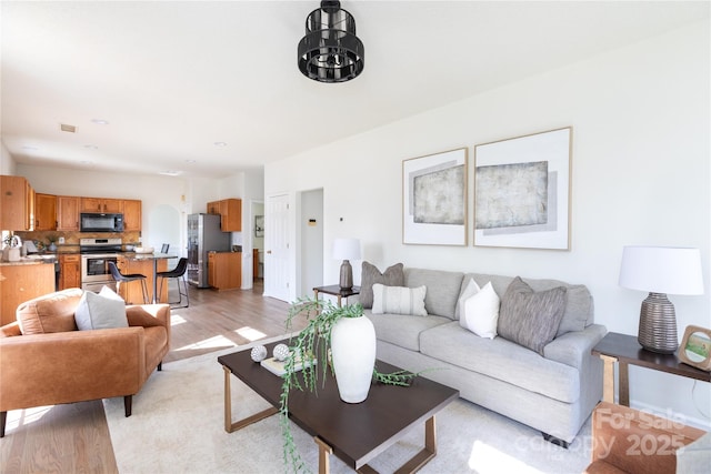 living area featuring light wood-style floors and visible vents