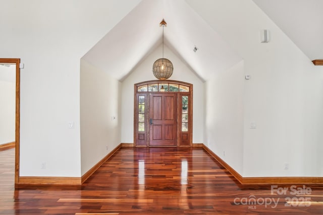 foyer entrance featuring baseboards, vaulted ceiling, and wood finished floors