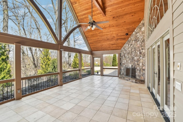 unfurnished sunroom featuring wooden ceiling, tile patterned flooring, and high vaulted ceiling