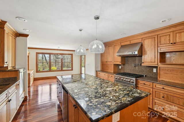 kitchen featuring a center island, tasteful backsplash, stainless steel appliances, wall chimney exhaust hood, and dark wood-style floors