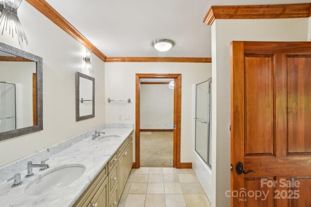 full bathroom featuring tile patterned floors, a sink, double vanity, and crown molding