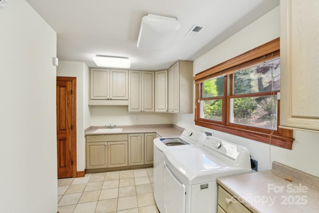 clothes washing area featuring a sink, washer and clothes dryer, visible vents, cabinet space, and light tile patterned floors