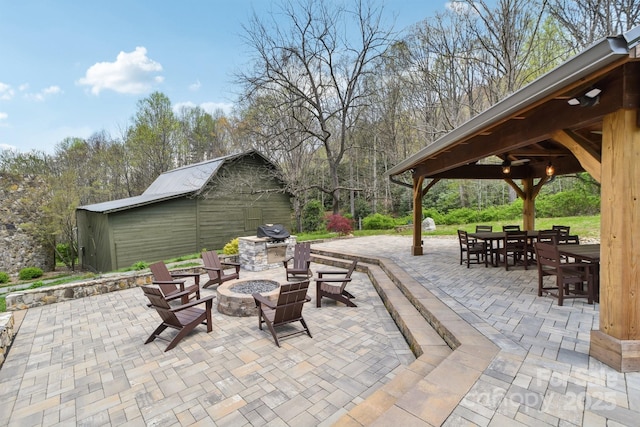 view of patio featuring area for grilling, a fire pit, a gazebo, and outdoor dining space