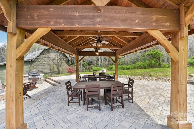 view of patio with a gazebo, outdoor dining space, ceiling fan, and area for grilling