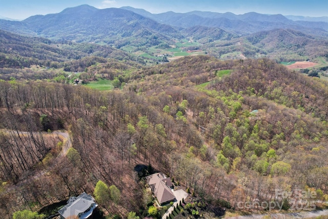 drone / aerial view featuring a mountain view and a wooded view