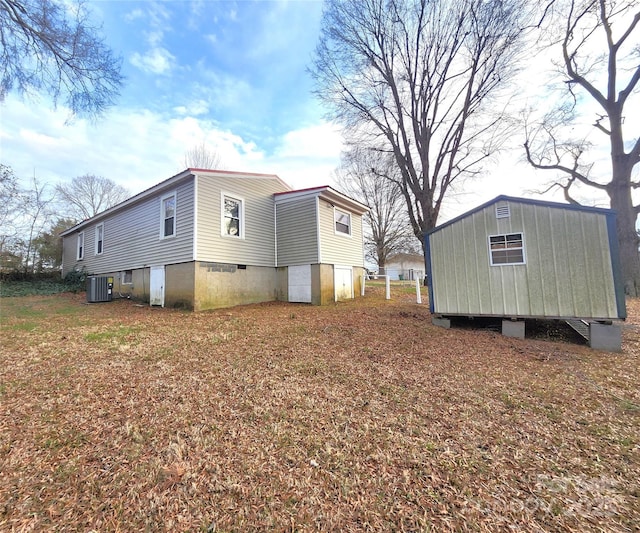 view of side of property featuring an outbuilding, a shed, and central air condition unit