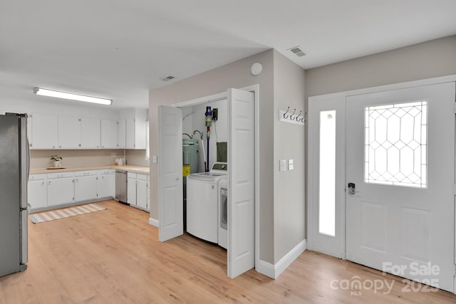 905 Blalock Dr, Kings Mountain, NC 28086 - kitchen with appliances with stainless steel finishes, washing machine and clothes dryer, light countertops, white cabinetry, and light wood finished floors