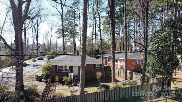 view of side of property with brick siding and fence