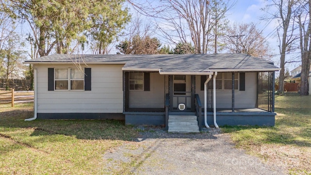 view of front of home featuring a shingled roof, a front yard, and covered porch