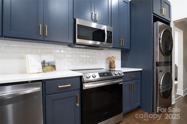 kitchen with blue cabinets, stacked washer / drying machine, and appliances with stainless steel finishes