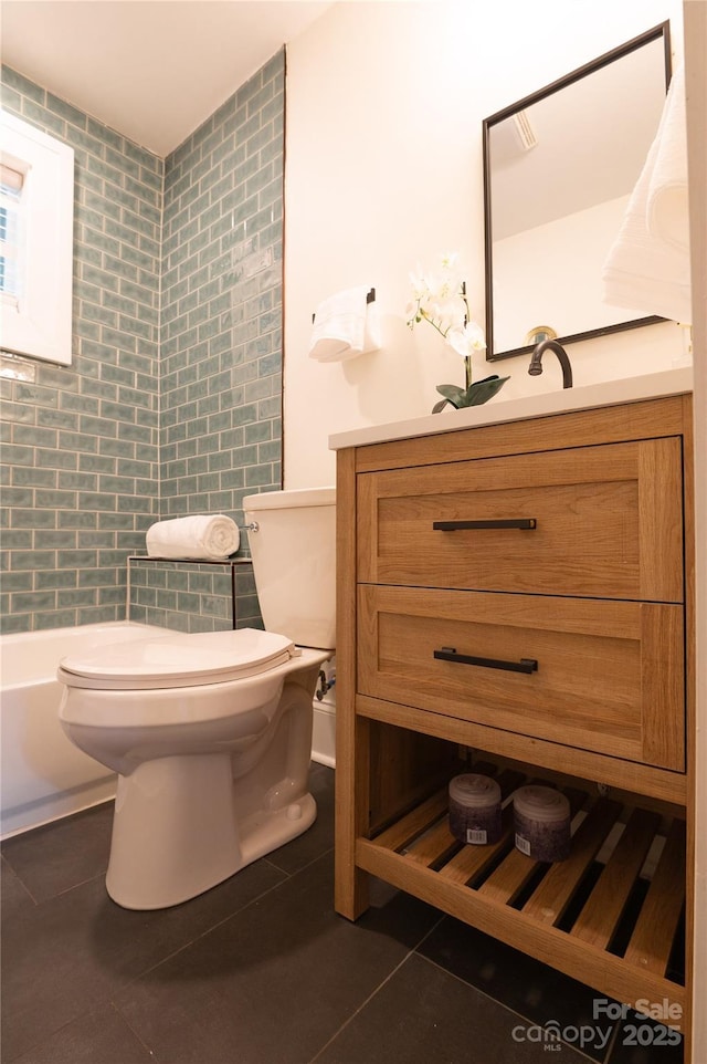 bathroom featuring tile patterned flooring, tile walls, toilet, and vanity