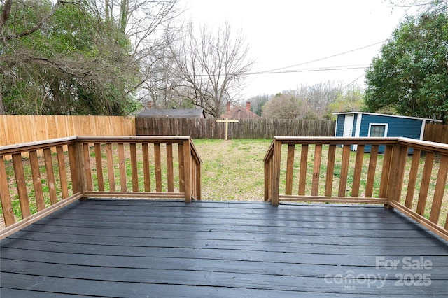 deck with a yard, an outdoor structure, and a fenced backyard