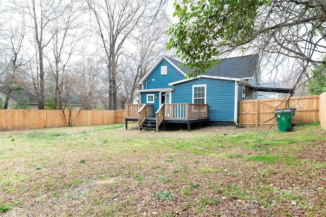 rear view of property with a wooden deck, a yard, and a fenced backyard