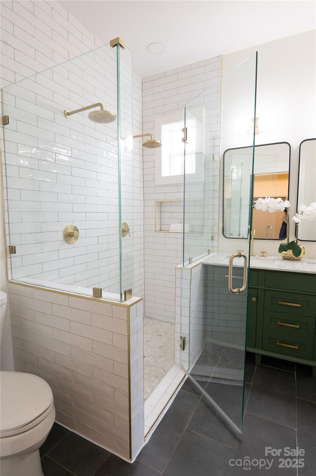 bathroom with tile patterned floors, a shower stall, toilet, and vanity