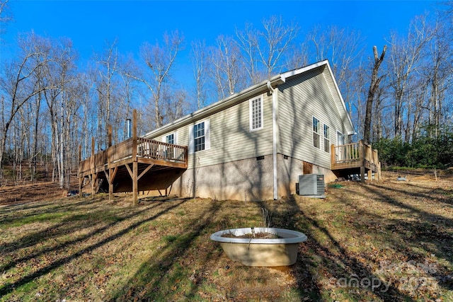 back of house featuring cooling unit and a wooden deck