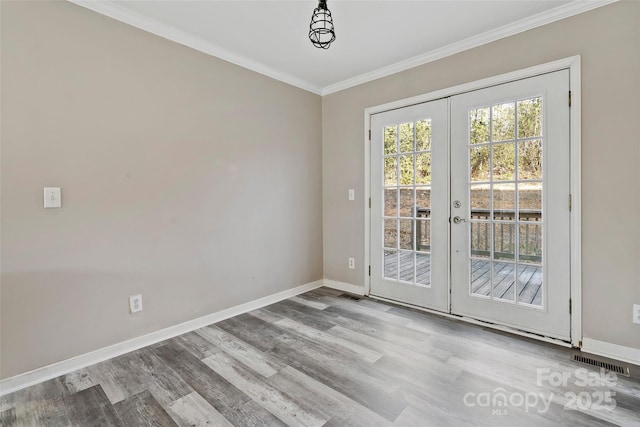 spare room featuring baseboards, visible vents, french doors, and ornamental molding