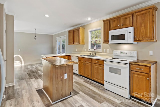 kitchen with ornamental molding, a peninsula, light wood-style floors, white appliances, and a sink