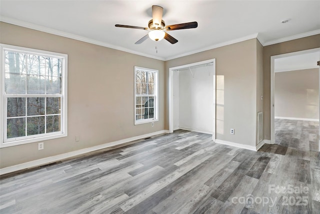 unfurnished bedroom featuring a closet, wood finished floors, baseboards, and ornamental molding