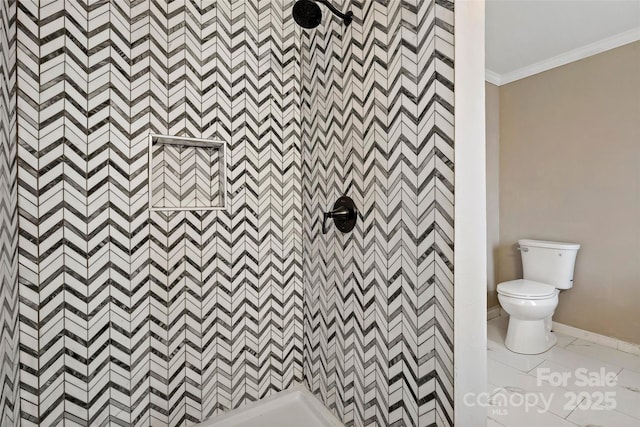 bathroom with crown molding, toilet, and tiled shower