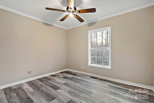 unfurnished room featuring visible vents, ceiling fan, baseboards, ornamental molding, and wood finished floors