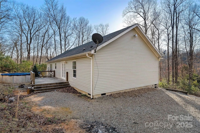 view of property exterior with crawl space, an outdoor pool, and a deck