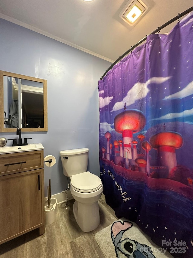 bathroom featuring a shower with curtain, toilet, ornamental molding, wood finished floors, and vanity