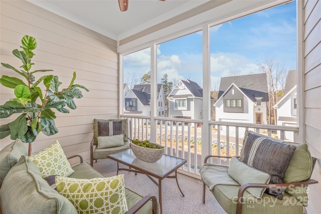 sunroom featuring a residential view and a ceiling fan