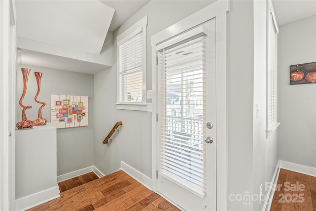 doorway to outside with baseboards and wood finished floors