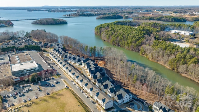 birds eye view of property featuring a water view and a wooded view